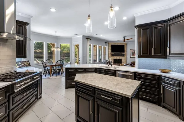 a kitchen with a stove a sink a microwave and chairs