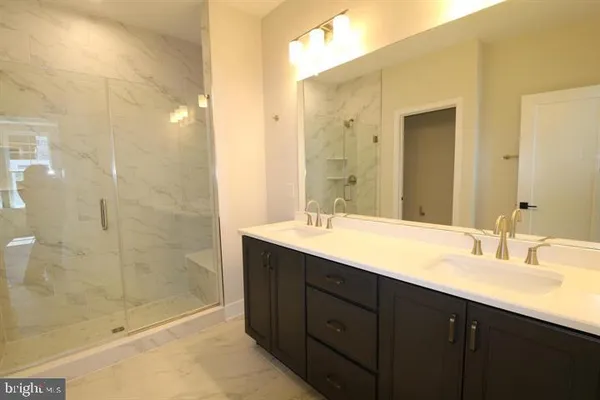 a bathroom with a double vanity sink mirror and shower