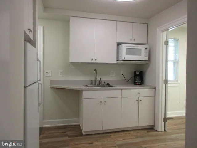 a kitchen with granite countertop white cabinets and sink