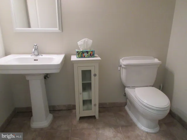 a white toilet sitting next to a bathroom sink