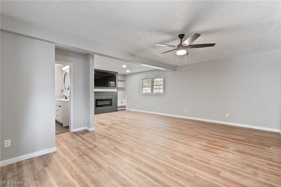 59636 Broadview Road Shadyside, OH 43947 - Photo 13 of 31 Unfurnished living room featuring a textured ceiling, light hardwood floors, and ceiling fan