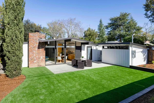 a view of a house with backyard and sitting area