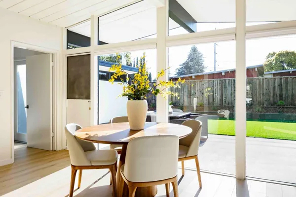 a dining room with furniture a fireplace and wooden floor