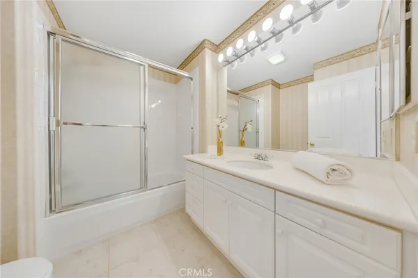 a spacious bathroom with a shower sink and mirror