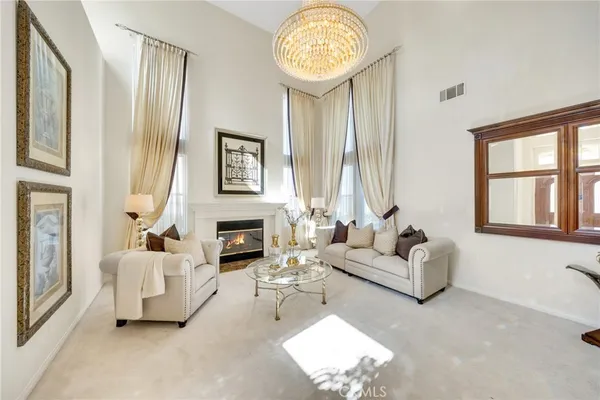 a living room with furniture a fireplace and a chandelier