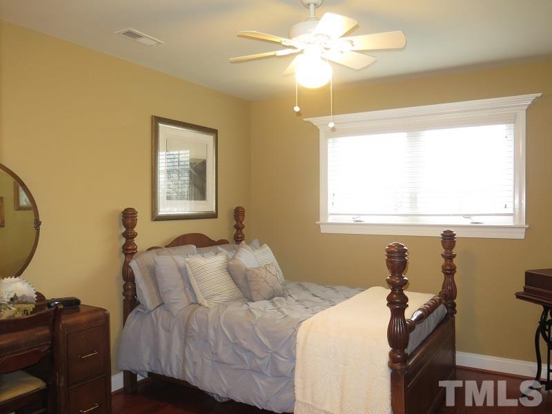 8733 Oregon Inlet Court Raleigh, NC 27603 - Photo 13 of 19 a bedroom with a bed and a chandelier