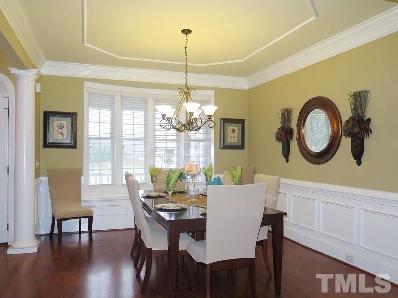 8733 Oregon Inlet Court Raleigh, NC 27603 - Photo 3 of 19 a dining room with wooden floor a chandelier a wooden table and chairs