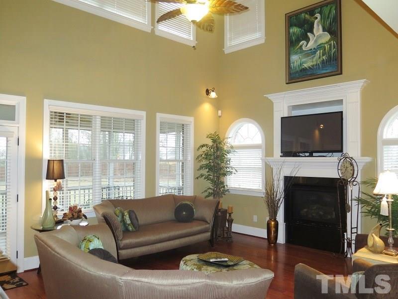 8733 Oregon Inlet Court Raleigh, NC 27603 - Photo 4 of 19 a living room with furniture a fireplace and a flat screen tv