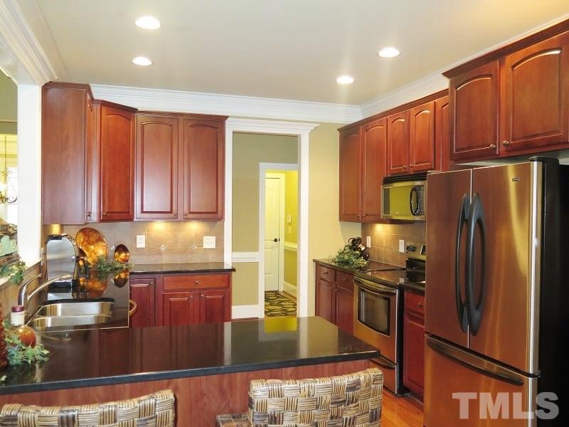 8733 Oregon Inlet Court Raleigh, NC 27603 - Photo 6 of 19 a kitchen with stainless steel appliances granite countertop a refrigerator a stove and a sink