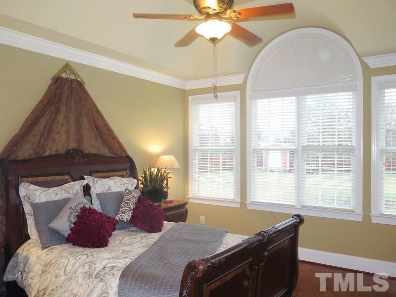8733 Oregon Inlet Court Raleigh, NC 27603 - Photo 8 of 19 a bedroom with a bed and a window