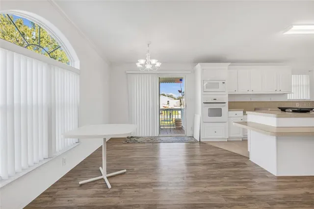 a view of a kitchen with wooden floor and electronic appliances