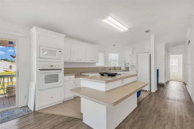 a kitchen with white cabinets and white appliances
