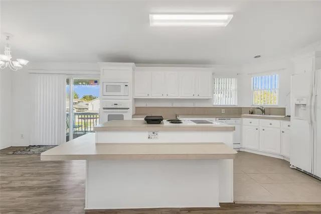 a view with cabinets a sink and appliances