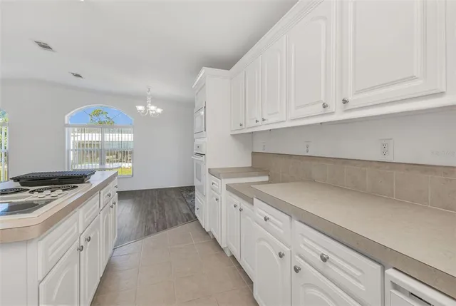 a kitchen with granite countertop a sink a stove and cabinets