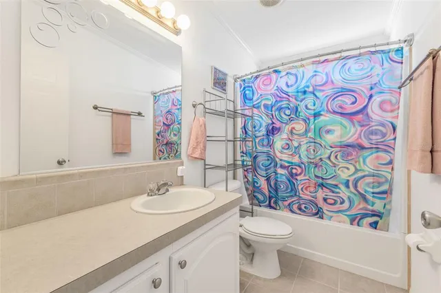 a bathroom with a sink a toilet and a shower curtain