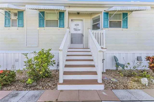 a front view of a house with plants and entryway