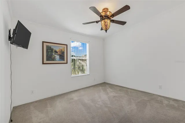 an empty room with a window and a fan