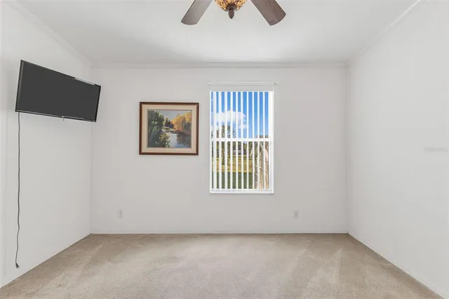 an empty room with windows and ceiling fan