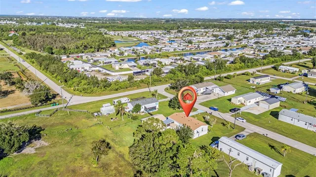 an aerial view of a house with swimming pool and green space