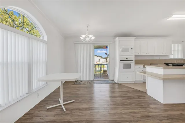 a view of a kitchen with wooden floor and electronic appliances