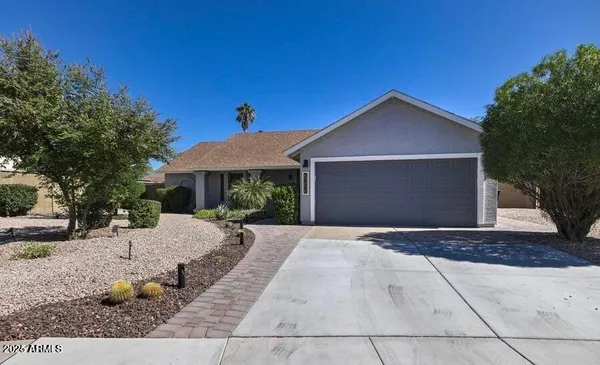 a front view of a house with a yard and trees