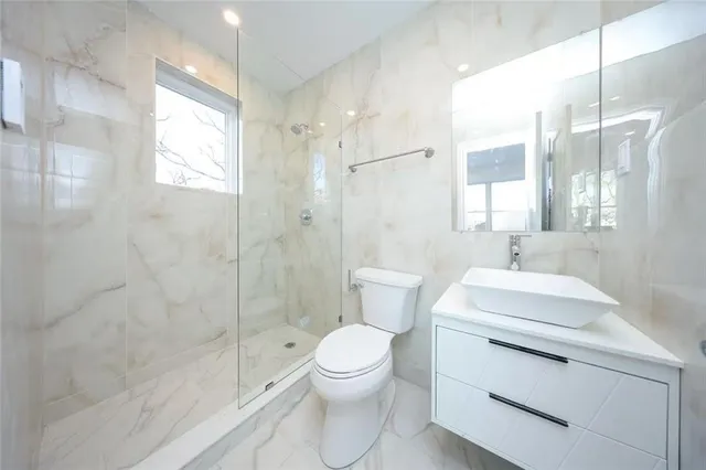 a bathroom with a sink a toilet and shower