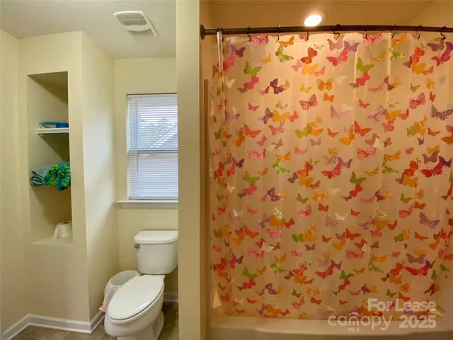 a white toilet sitting next to a shower curtain