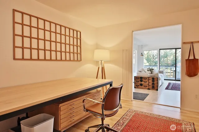 a living room with furniture a large window and wooden floor
