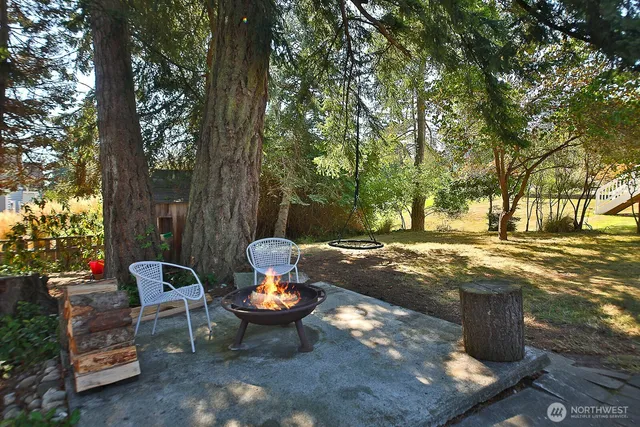 a view of a backyard with table and chairs couches and a fire pit