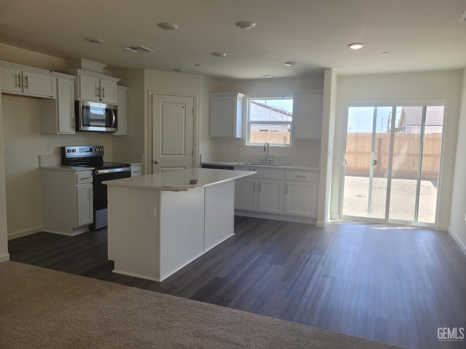 Undisclosed Address Bakersfield, CA 93311 - Photo 6 of 24 a view of a kitchen with a sink wooden floor and windows