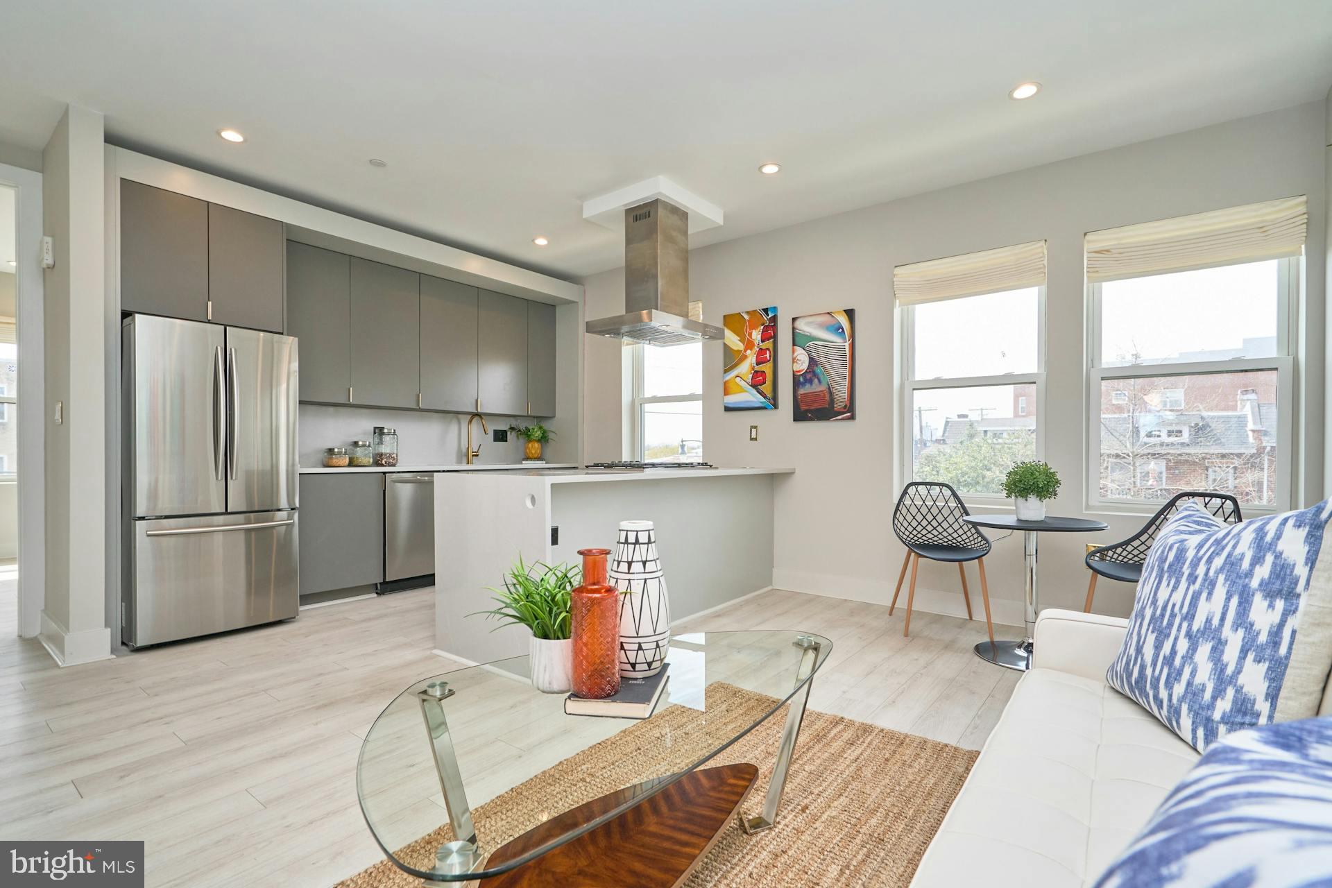a kitchen with stainless steel appliances granite countertop a refrigerator and a dining table