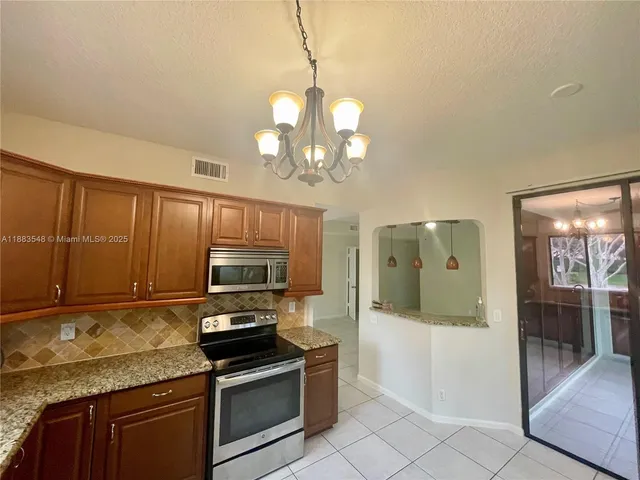 a kitchen with granite countertop a stove cabinets and microwave