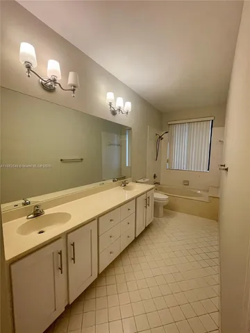 a bathroom with a sink mirror and a bathtub