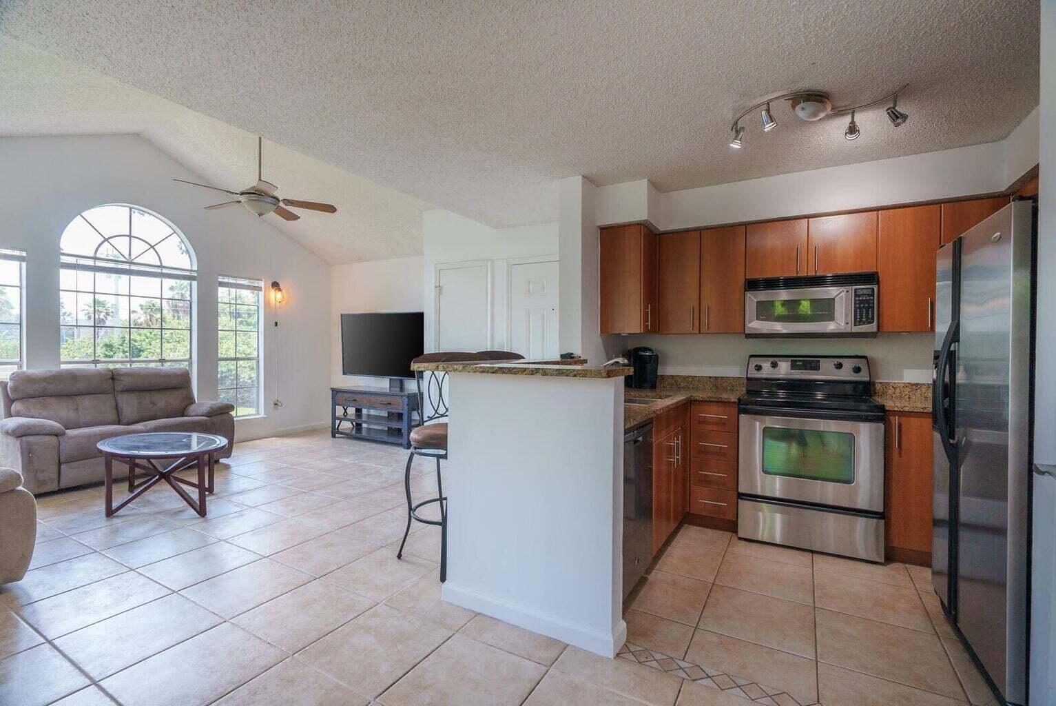 1050 Crystal Way, Unit P Delray Beach, FL 33444 - Photo 3 of 17 a kitchen with stainless steel appliances a stove a sink and a microwave