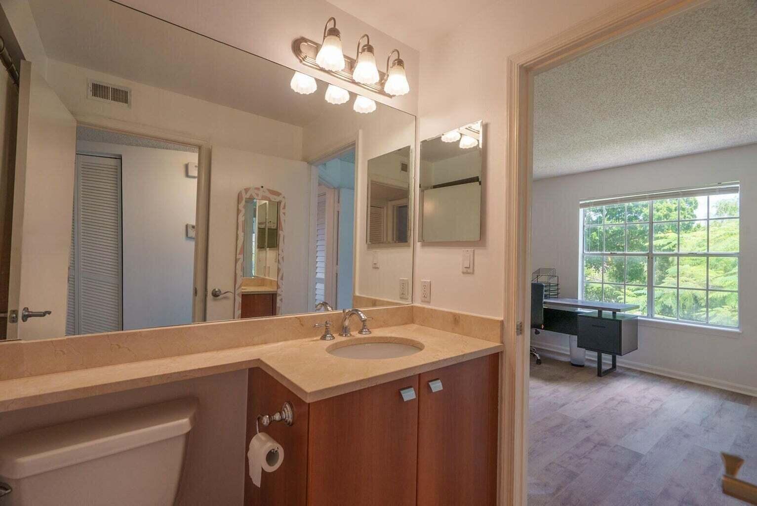 1050 Crystal Way, Unit P Delray Beach, FL 33444 - Photo 9 of 17 a spacious bathroom with a granite countertop sink a large mirror and a bathtub