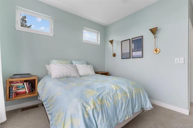 a bedroom with a bed and a painting on the wall