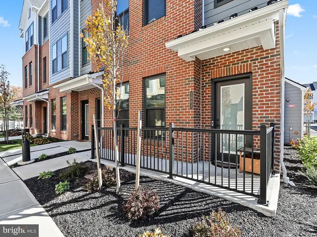 a view of a brick house with large windows and a table