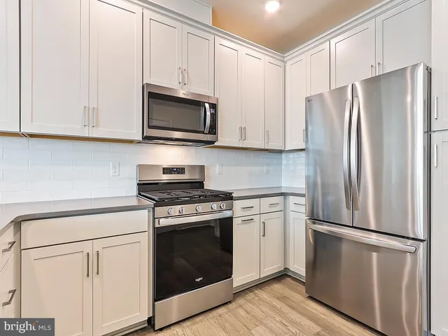 a kitchen with stainless steel appliances white cabinets white stove and refrigerator