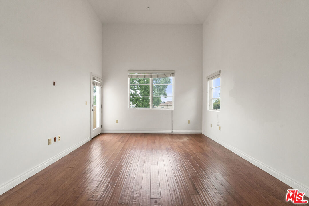 10765 Wilkins Avenue, Unit 8 Los Angeles, CA 90024 - Photo 13 of 33 an empty room with wooden floor and windows