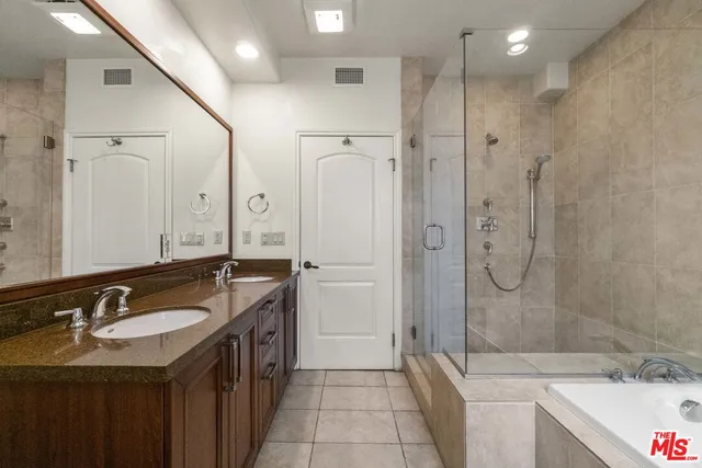 a spacious bathroom with a granite countertop sink mirror and shower