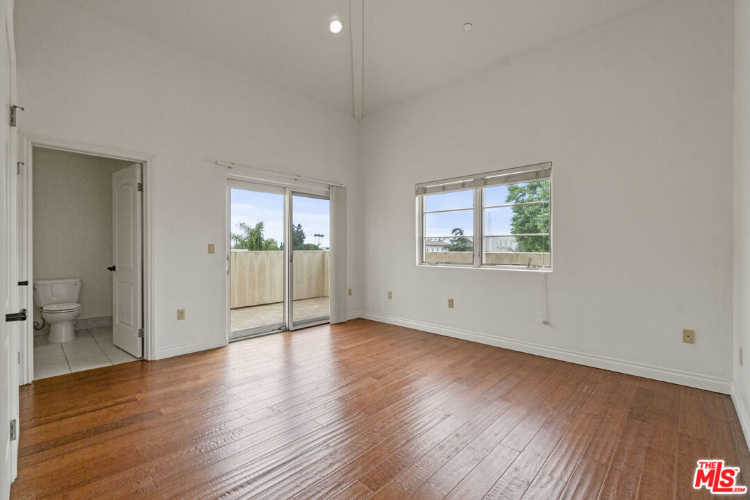 10765 Wilkins Avenue, Unit 8 Los Angeles, CA 90024 - Photo 22 of 33 an empty room with wooden floor and windows
