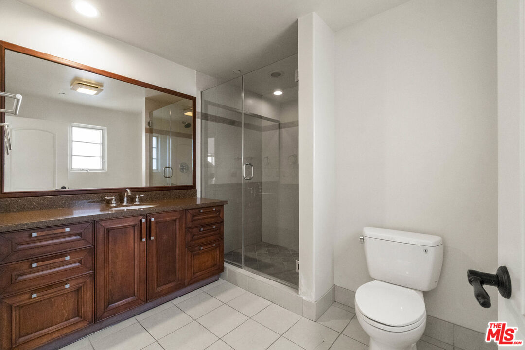 10765 Wilkins Avenue, Unit 8 Los Angeles, CA 90024 - Photo 24 of 33 a bathroom with a toilet a sink and glass door
