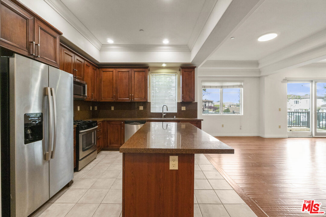 10765 Wilkins Avenue, Unit 8 Los Angeles, CA 90024 - Photo 4 of 33 a kitchen with stainless steel appliances granite countertop a refrigerator a sink a stove a oven with wooden cabinets and glass door