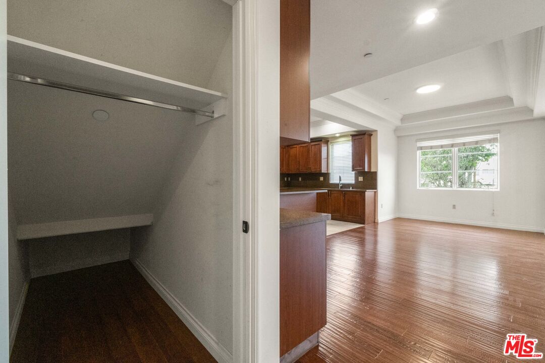 10765 Wilkins Avenue, Unit 8 Los Angeles, CA 90024 - Photo 10 of 33 a view of a kitchen and an empty room with wooden floor and a window