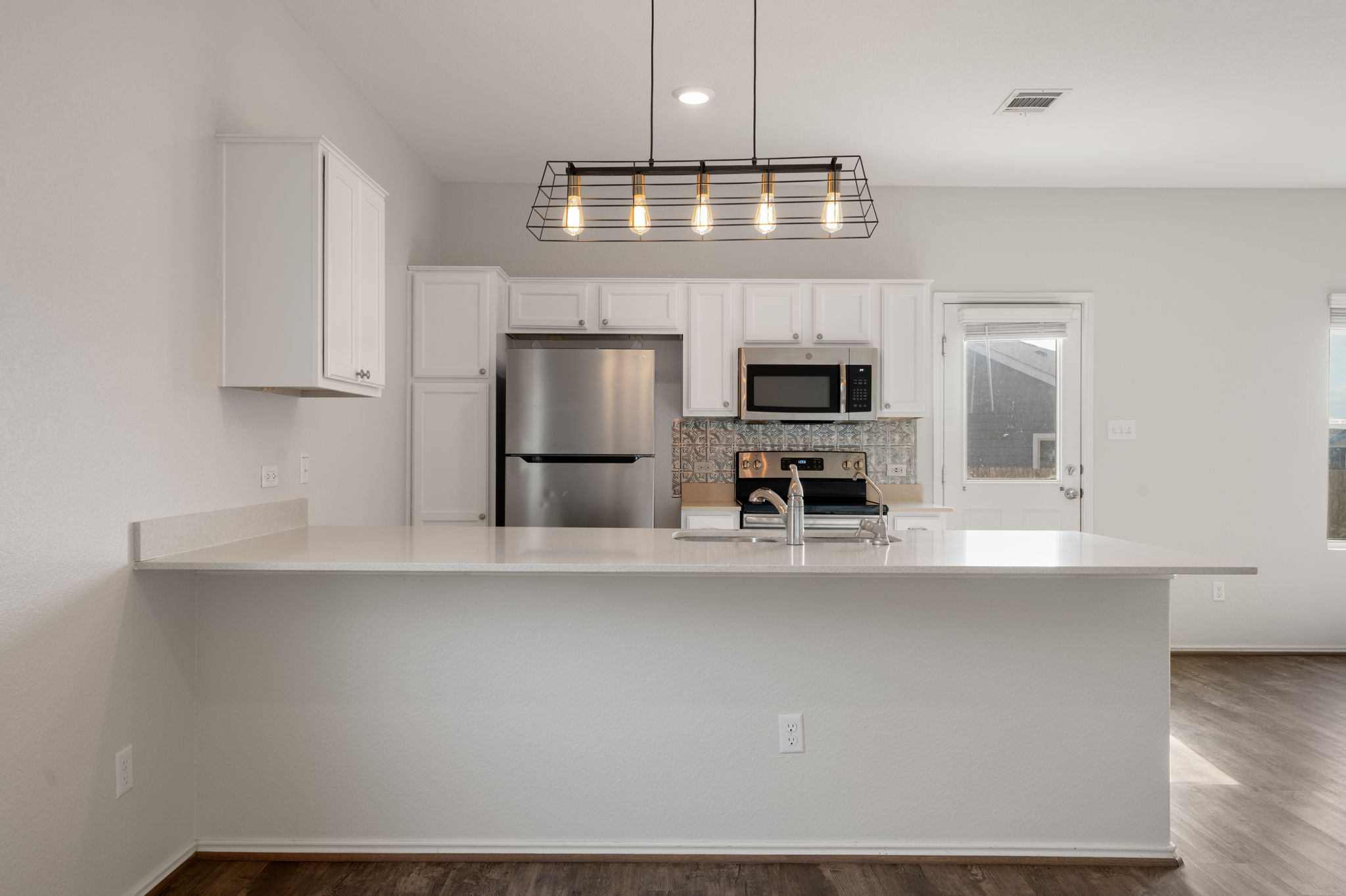 817 Circle Way Jarrell, TX 76537 - Photo 9 of 39 a kitchen with kitchen island white cabinets and stainless steel appliances