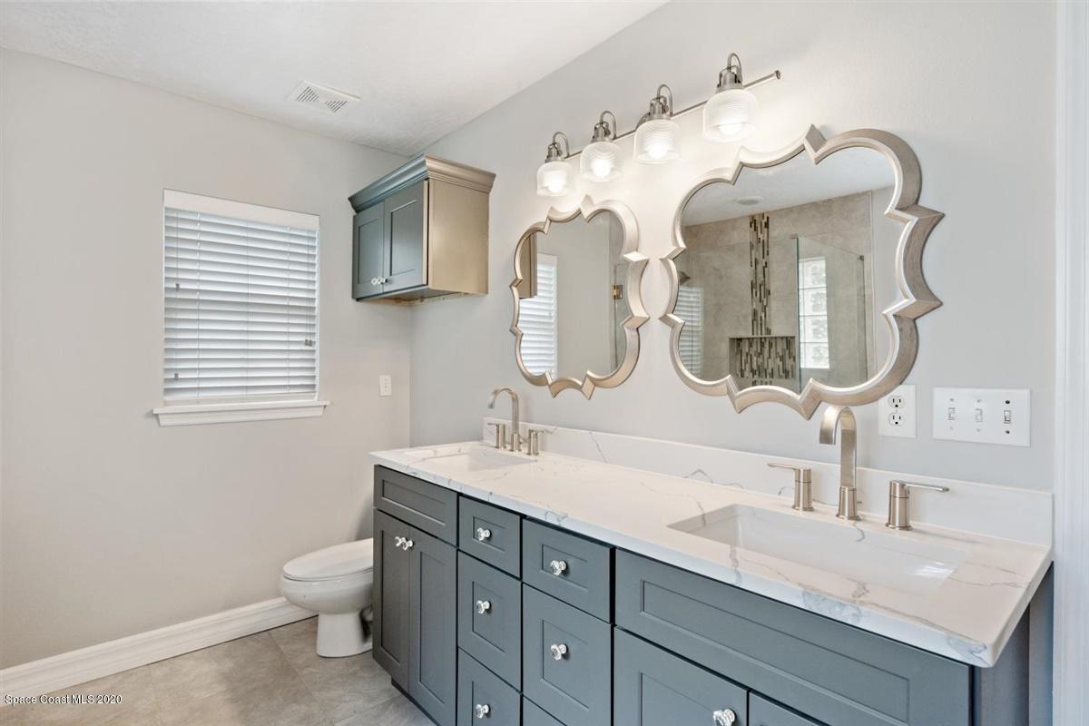 5551 Senne Road Micco, FL 32976 - Photo 13 of 37 a bathroom with a double vanity sink and a mirror