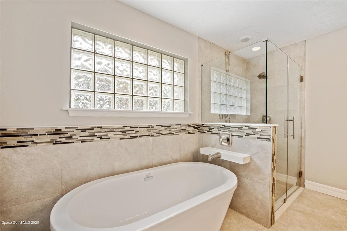 5551 Senne Road Micco, FL 32976 - Photo 14 of 37 a bathroom with a tub sink and mirror