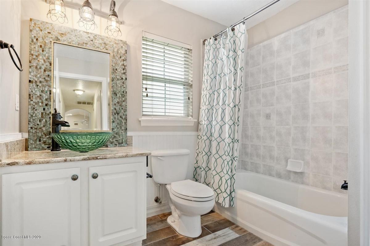 5551 Senne Road Micco, FL 32976 - Photo 18 of 37 a bathroom with a granite countertop toilet a sink and a bathtub