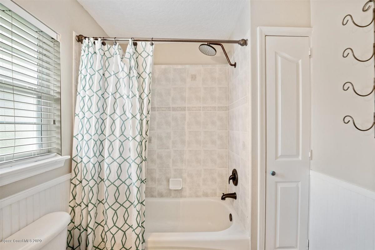 5551 Senne Road Micco, FL 32976 - Photo 19 of 37 a bathroom with a shower curtain and a shower curtain