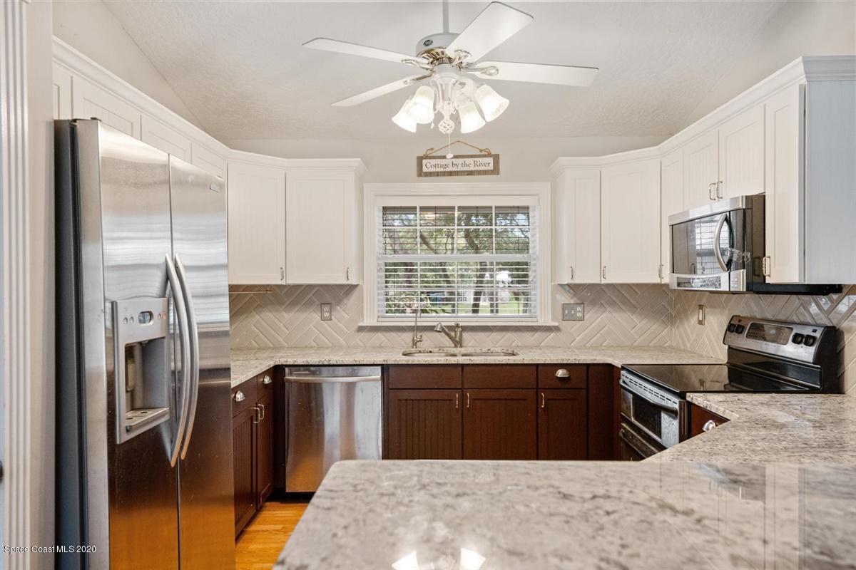 5551 Senne Road Micco, FL 32976 - Photo 7 of 37 a kitchen with a sink stove and refrigerator